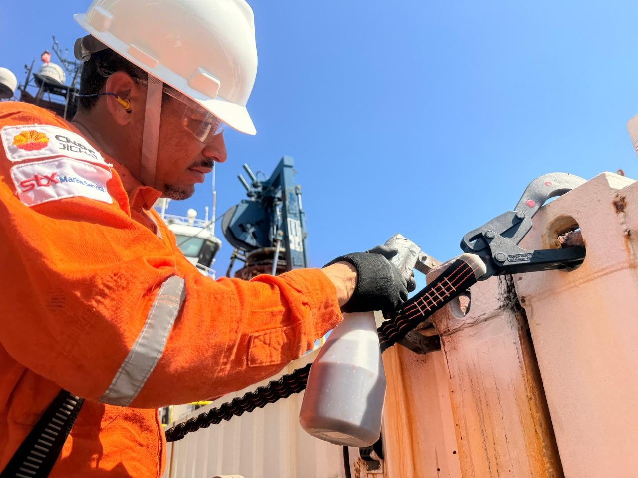 Técnico inspecionando olhal de içamento de container antes da movimentação de carga